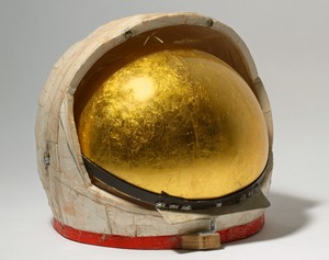 Tom Sachs, Gold Helmet, 2011. Duct tape, foam core, thermal adhesive, gold leaf, steel, plexiglass, synthetic polymer paint, and plywood, 12 ½ × 13 × 13 ½ inches (31.8 × 33 × 34.3 cm) © Tom Sachs. Photo: Genevieve Hanson