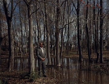 Man in a suit standing in the woods