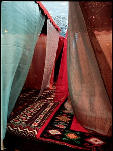 Chris Burden, Nomadic Folly, 2001 (detail). Wood platform, 4 cloth and metal umbrellas, woven carpets, braided ropes and pillows, silken fabrics, glass and metal lamps, and CD player and speakers, 11 ½ × 20 × 20 feet (3.5 × 6.1 × 6.1 m) © Chris Burden
