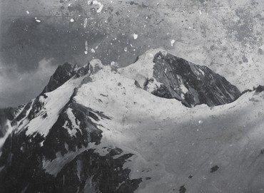 A snowy mountain range in black and white.