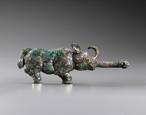 Daigou in the shape of a rhinoceros, Warring States period (481–221 BCE). Bronze inlaid with gold and silver, malachite encrustation, and traces of cuprite and crystallized textile, height: 3 ⅜ inches (8.5 cm), width: 9 ⅝ inches (24 cm)