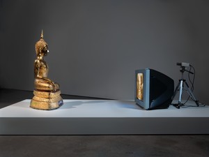 Nam June Paik, Golden Buddha, 2005. Closed-circuit video (color) with television and wood Buddha with permanent oil marker, 46 ½ × 106 × 31 ¾ inches (118.1 × 269.2 × 80.6 cm) © Nam June Paik Estate