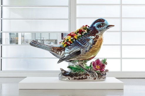 Jeff Koons, Bluebird Planter, 2010–16 Mirror-polished stainless steel with transparent color coating, and live flowering plants, 82 ½ × 110 ¾ × 40 inches (209.6 × 281.3 × 101.6 cm), edition of 3 + 1 AP© Jeff Koons. Photo: Fredrik Nilsen