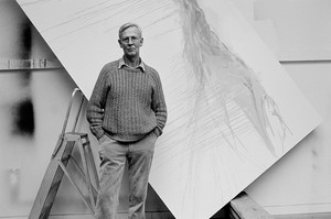 Bruce Bernard, Michael Andrews in his Norfolk studio; behind the artist, “A View from Uamh Mhòr” in an early state, 1990 (posthumously printed 2016). Silver bromide print, 11 ¾ × 17 ½ inches (29.8 × 44.3 cm), edition of 25 © The Estate of Bruce Bernard (courtesy Virginia Verran)