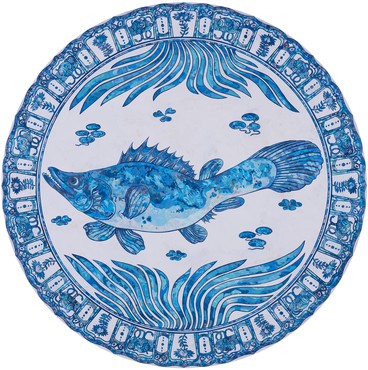 Circular painting made in blue and white paint featuring a fish in the center surrounded by design motif
