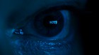 Close-up of an eye cast in blue light with the word "Boys" over the pupil