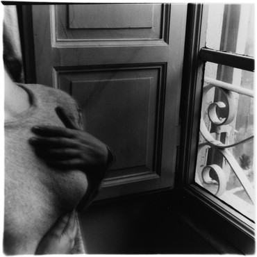 Partially visible woman with her hands on her chest near an open window