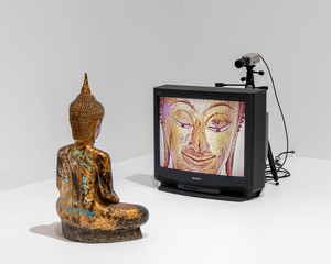 Nam June Paik Gold TV Buddha, 2005. Closed-circuit video (color, silent), 27-inch monitor, video camera, tripod, cables, and permanent oil marker on gilded bronze Buddha, 31 ½ × 26 × 85 inches (80 × 66 × 215.9 cm) © Nam June Paik Estate. Photo: Paula Abreu Pita, Brooklyn Museum