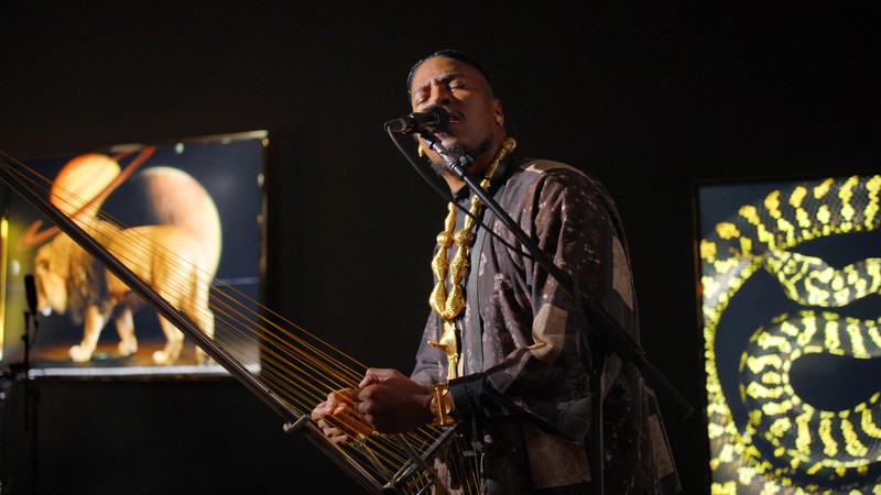 Chief Xian aTunde Adjuah playing the Adjuah Bow in Awol Erizku’s exhibition, Memories of a Lost Sphinx