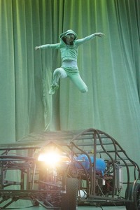Dancer on a car leaps in the air