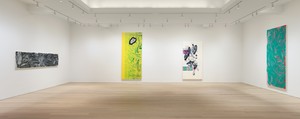gallery with colorful paintings, light wood floor, and white walls