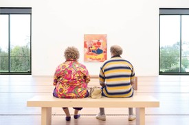 A sculpture by the artist Duane Hanson of two human figures sitting on a bench