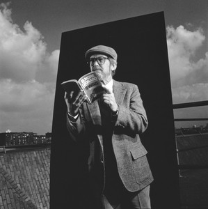 Black and white portrait of Elmore Leonard reading one of his books