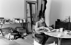 Black and white image of Francis Bacon sitting in his studio