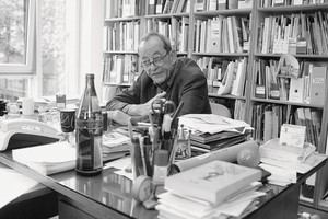 Black and white portrait of Kasper König sitting at a desk