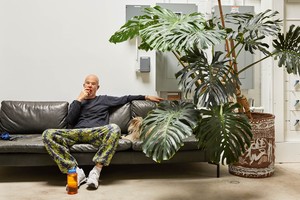 Portrait of Jonas Wood in his Los Angeles studio, he bites a piece of fruit