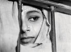 Still from The World of Apu (1959), directed by Satyajit Ray, it features a close up shot of a person crying, only half of their face is visible, the rest is hidden behind fabric