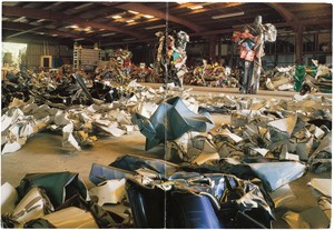 Exhibition announcement card for the John Chamberlain's show "Reliefs 1960–1982" features an image of inside the artist's studio