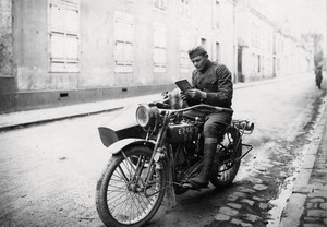 Black and white portrait of a person on a motorcycle reading a book