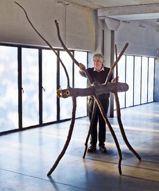 Image of the artist and his tree-like sculpture