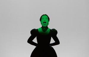 Actress Isabelle Huppert dressed as Mary Queen of Scots with a green light illuminating her face