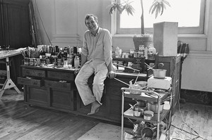Black and white image of Jasper Johns sitting in his studio