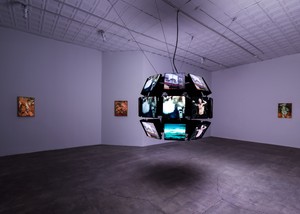 Video installation comprised of multiple screens suspended in a gallery space with three small paintings on the background walls