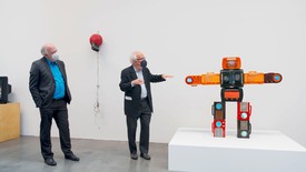 Jon Huffman and John G. Hanhardt stand in front of Nam June Paik’s “Bakelite Robot”