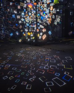 A multitude of paper screens animated with images, video, and light, forming a porous, illuminated core, like a room-sized kaleidoscope