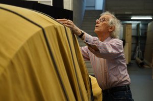 Christo wrapping a 1961 Volkswagen Beetle Saloon in mustard yellow tarpaulin and rope
