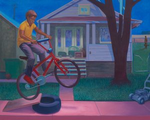 Black boy on a red bicycle riding over a wood plank propped on a car tire on a sidewalk in front of a house