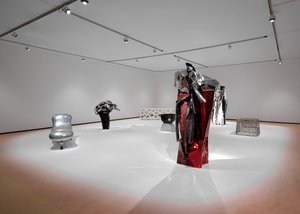 Installation of two sculptures made of car metal and an aluminum lounge, glass chair, and marble console