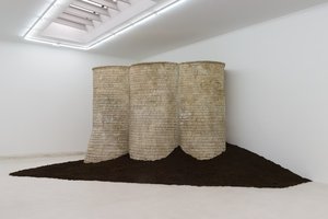 Three carved foam towers on top of a large pile of dirt