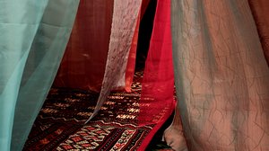 Detail of a sculpture with colorful tapestries and carpets
