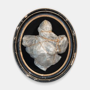 Black circular frame with a package inside wrapped in plastic and twine