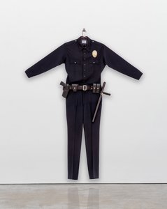 A police officer uniform fitted for an almost nine-foot person hanging on a wall