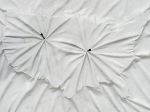 Marble sculpture with the outline of the United States with two nails punched through it