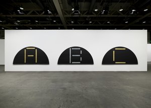 A trio of large semicircular canvases, each of which is painted with the letters A, B, and C, hanging on a wall
